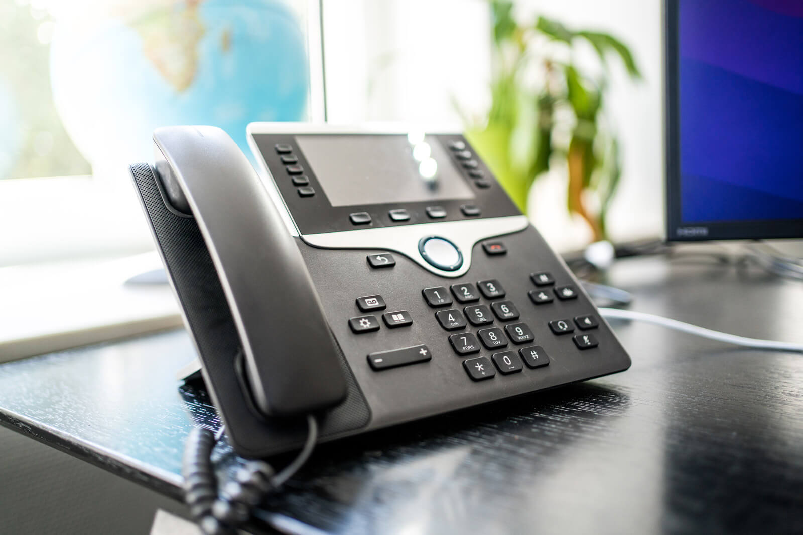 Professionelles Bürotelefon auf einem Schreibtisch — Symbol für hochwertige Telefonansagen