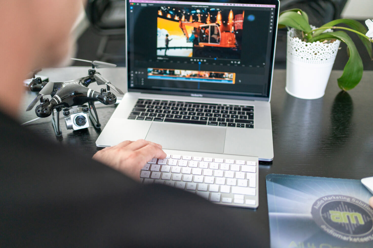 Videoschnitt am Notebook mit Kamera- und Drohnen-Equipment im Studio der audiomarketeers